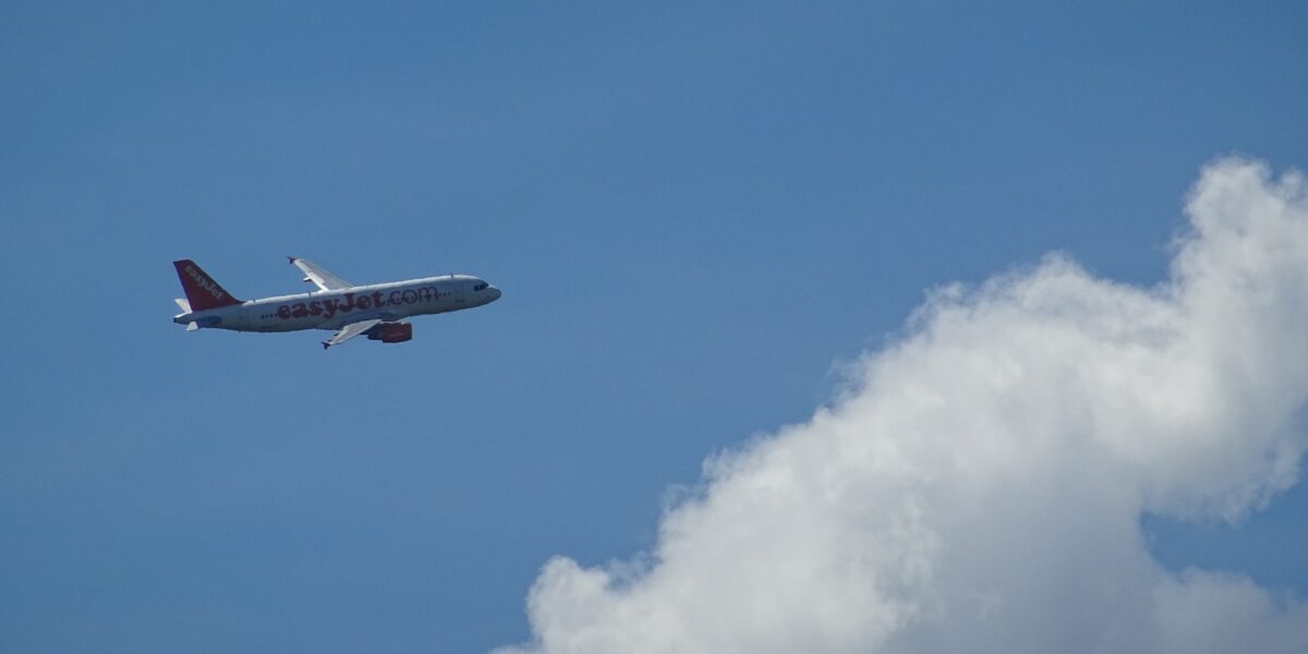 Commercial aircraft flying above cloud layer