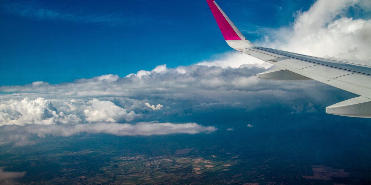 View from airplane window showing clouds and wing